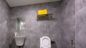 Een moderne badkamer met toilet, wastafel en douche.