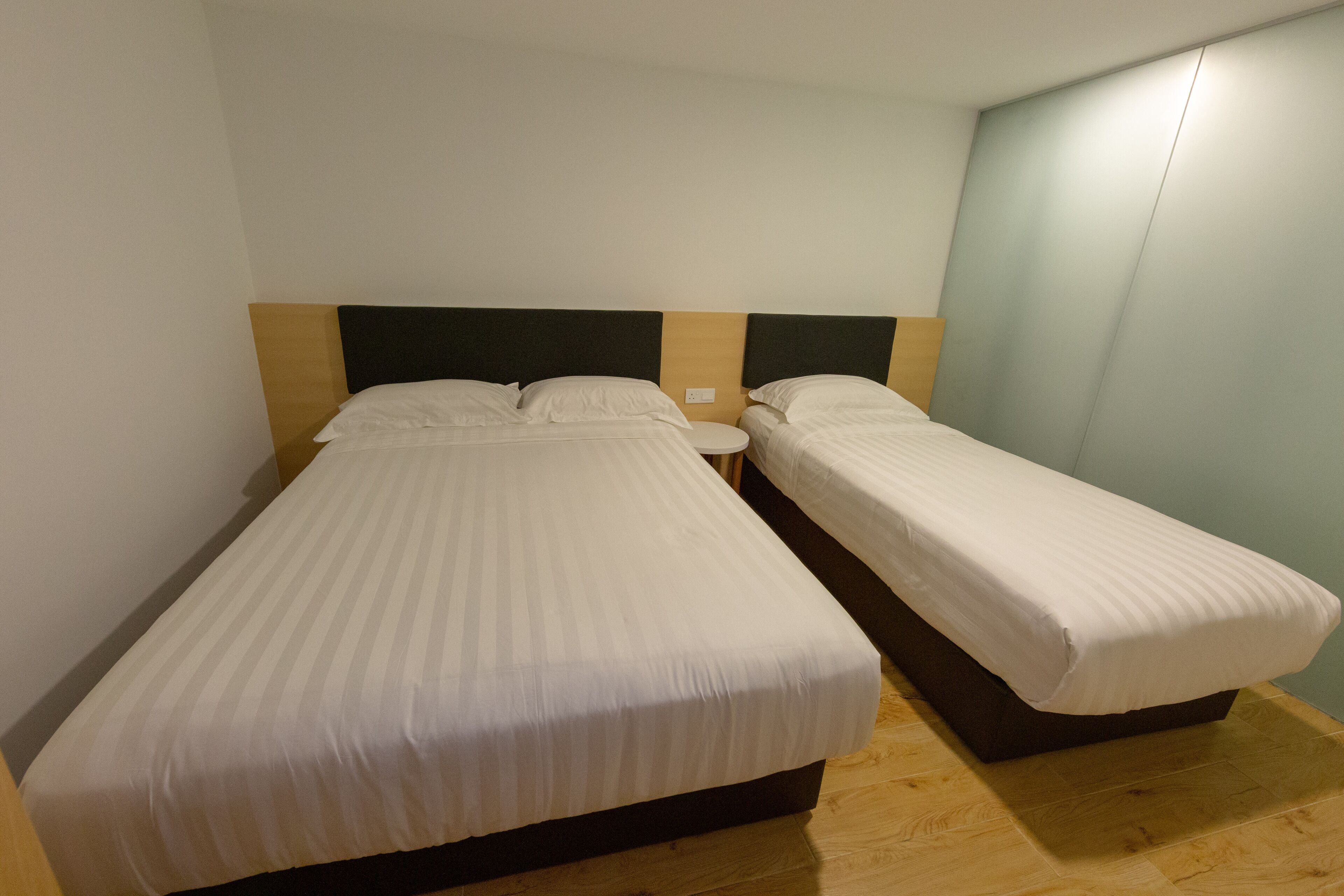 A double bed with a wooden headboard and a nightstand.