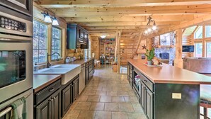 Interior de una cabaña de madera con cocina, comedor y sala de estar.