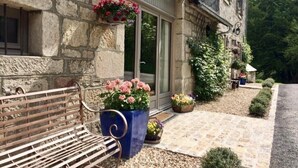 A stone building with a bench, potted plants, and a pathway leading to a door. - Romantic French country barn perfect for a couple/weekend breaks. (Gourdon-Murat)