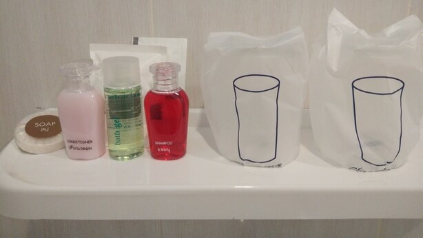 Un estante de baño con varios artículos de aseo, como jabón, champú y acondicionador.
