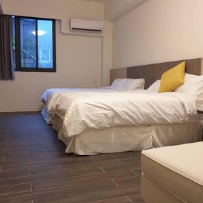 A hotel room with a large bed, a small sofa, and a window with curtains. - Mesin Inn (Magong)
