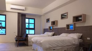 Habitación de hotel con dos camas, una silla, un escritorio y una ventana con cortinas.