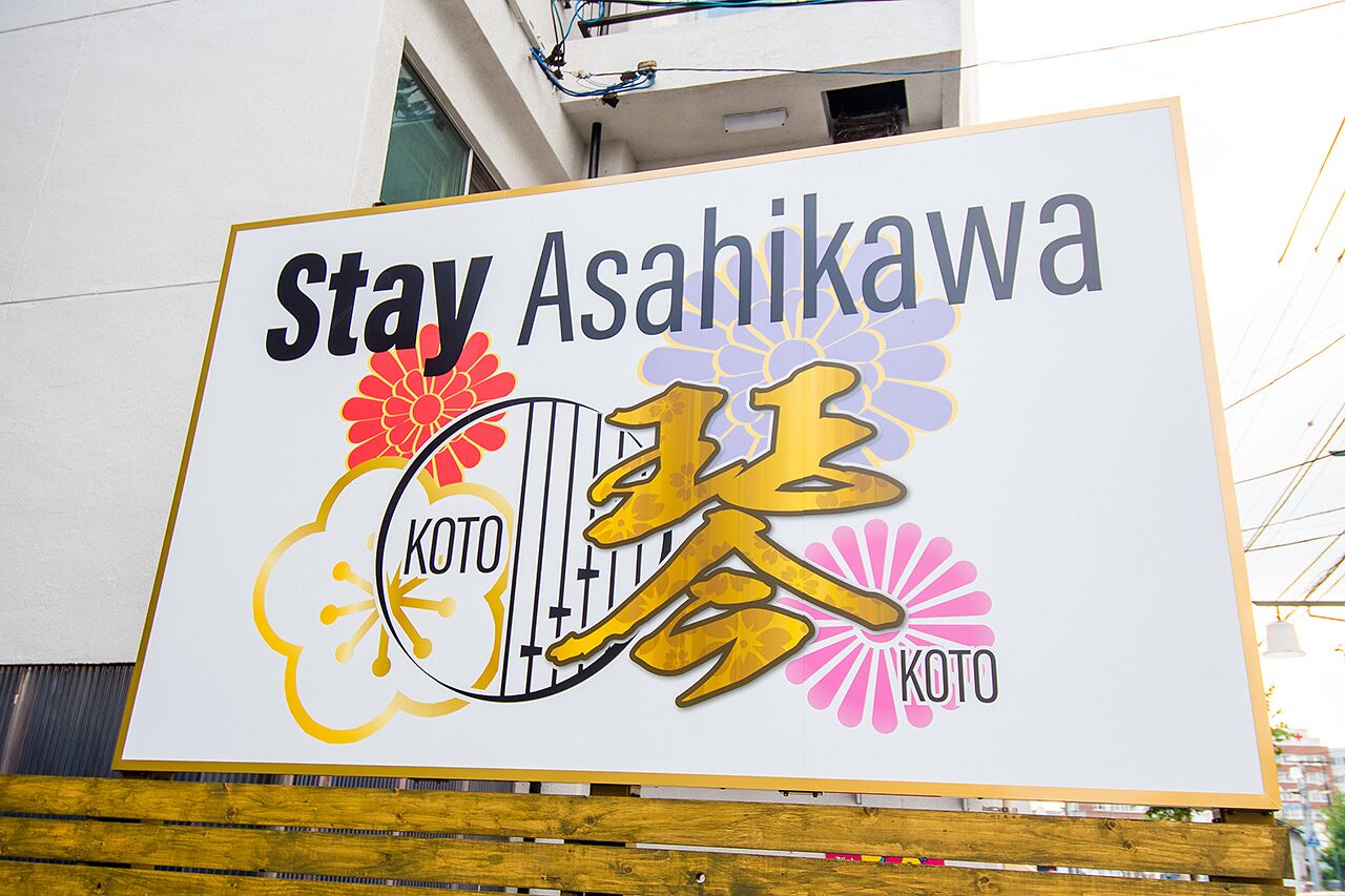 Une enseigne pour l’hôtel Stay Asahikawa, avec le logo KOTO.