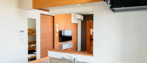 A compact kitchen with wooden cabinets, a stainless steel sink, and a built-in stove.