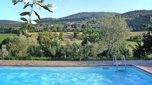 A swimming pool with a view of a hillside town and lush greenery. - Charming House in Tuscany with Pool & Views (Sovicille)