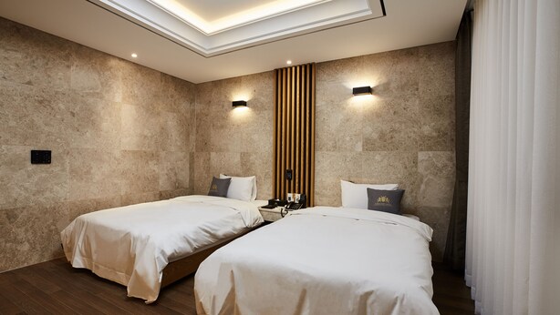 A hotel room with two beds, a wooden panel wall, and a skylight. - Noble Stay Hotel (Gwangju)