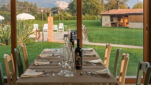 Une table à manger dressée pour six personnes, avec une bouteille de vin, des verres et des couverts.