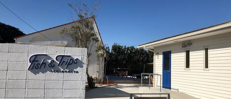 A building with a sign reading "Fish & Trips" and a sign indicating "Hotel Guests Only."
