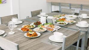 Mesa de jantar posta com diversos pratos, copos e talheres.
