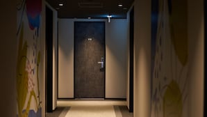 Un couloir avec une porte portant l’inscription « 910 » et un interrupteur situé au-dessus.