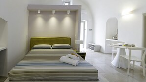 A modern hotel room with a large bed, a bedside table, a small desk, and a mirror. - Santa Marina Bed & Breakfast (Massafra)