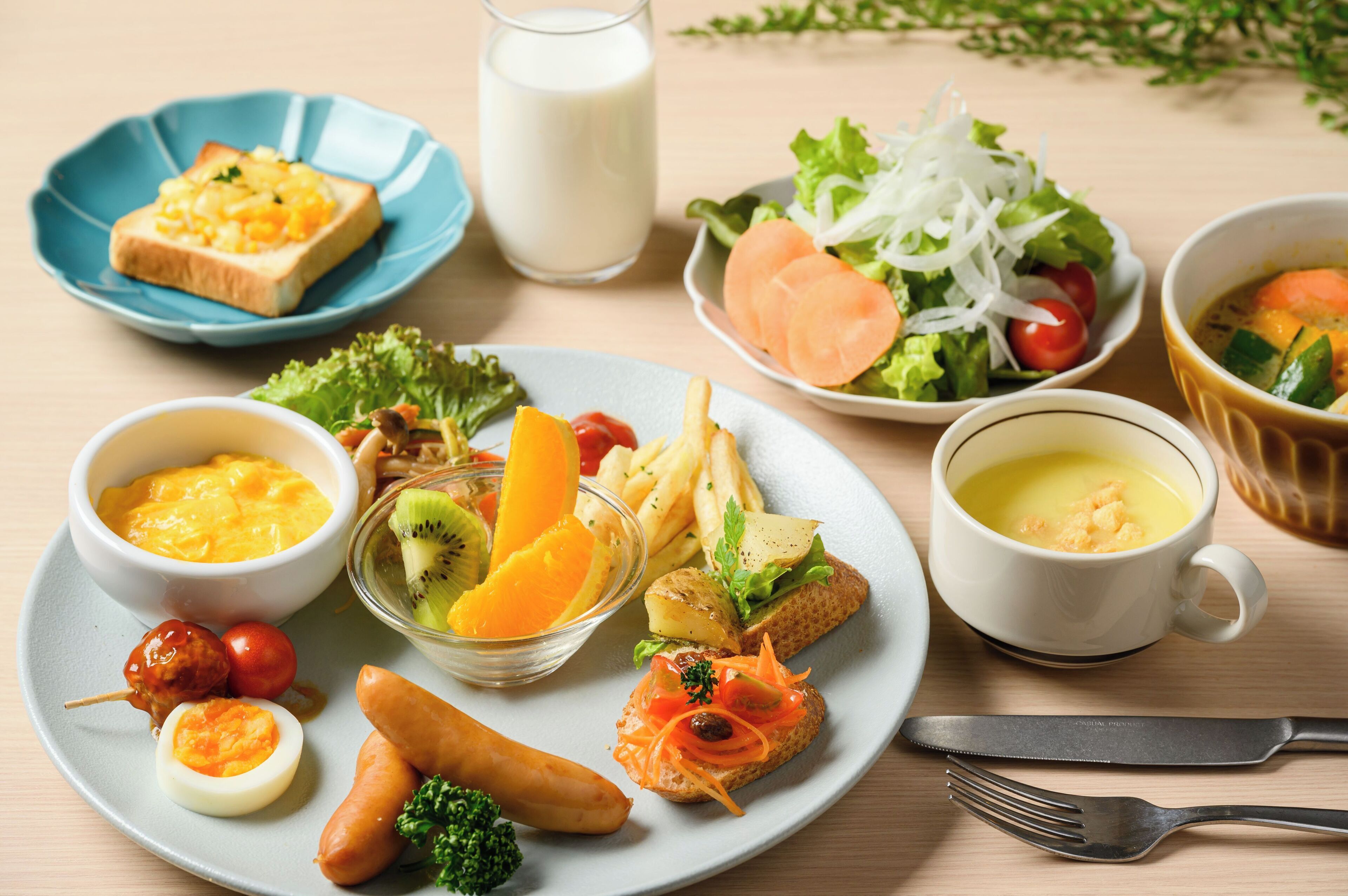 A variety of breakfast foods including toast, eggs, sausages, and a salad on a plate.