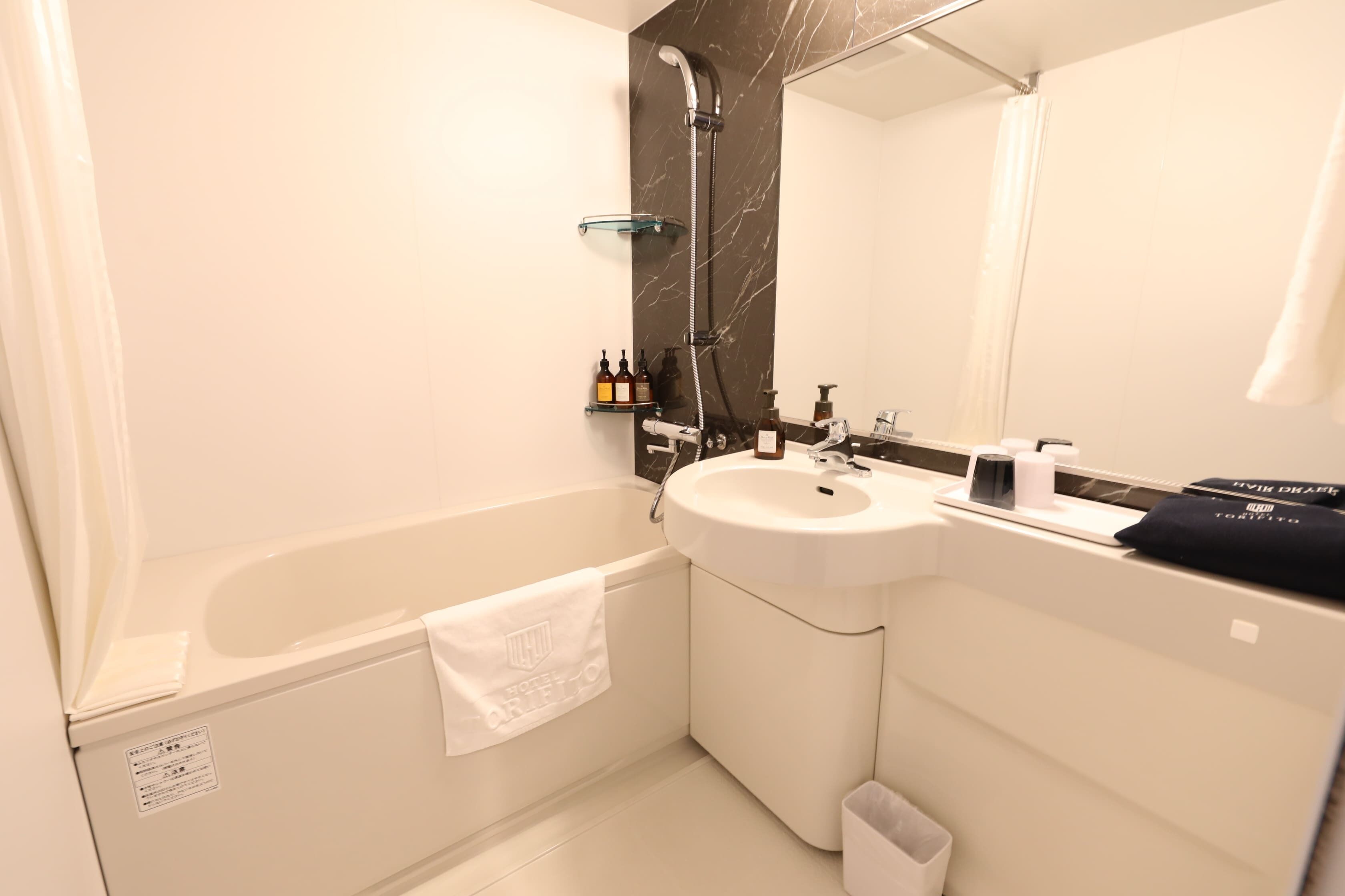 A modern bathroom with a bathtub, a sink, and a mirror.
