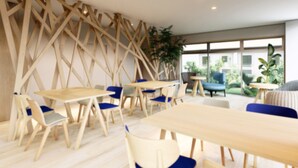 Een moderne binnenruimte met houten meubels, zoals tafels en stoelen, en een groot raam met uitzicht op de omgeving.