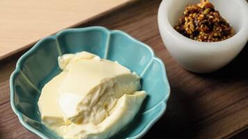 A blue bowl with a white substance, possibly butter, and a white bowl with a brown mixture.