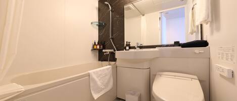 A modern bathroom with a bathtub, toilet, and sink.
