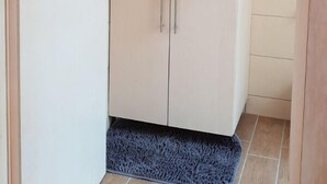 Une salle de bain avec un lavabo blanc, un miroir au-dessus et des meubles de couleur beige.