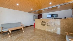 A reception area with a wooden ceiling, a reception desk, a television, and a sofa. - Floral Hotel Dianhu Holiday Shanghai (Shanghai)