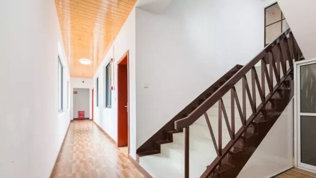 A hallway with wooden flooring and a staircase with a dark wooden railing. - Floral Hotel Dianhu Holiday Shanghai (Shanghai)