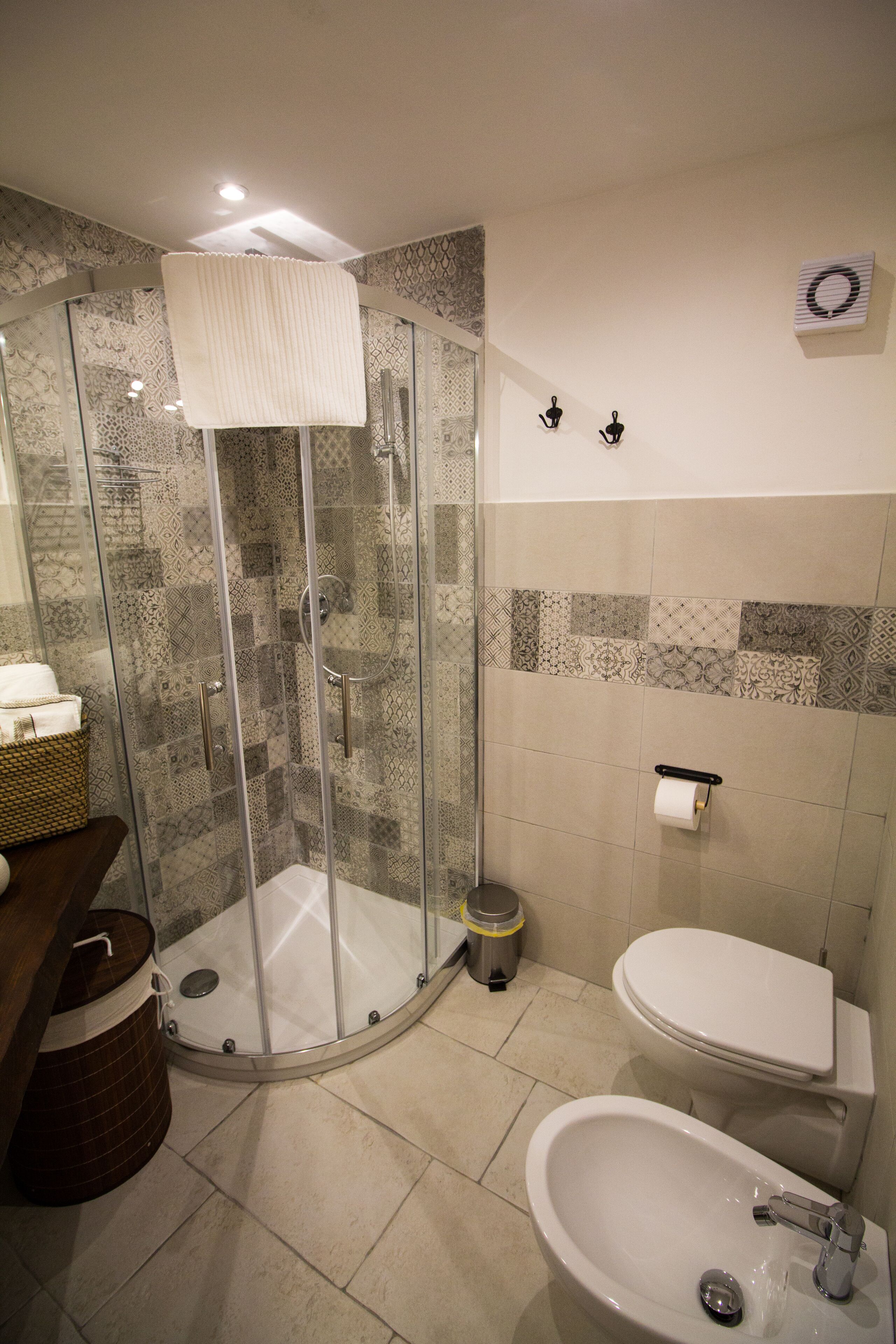 Et badeværelse med en brusekabine med glasvægge, toilet og vask.