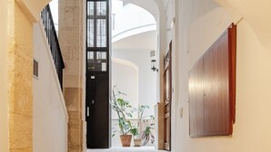 A staircase leading to a door with a window, potted plants, and a wall-mounted panel. - "LULLABY ROOM" APARTMENT BARI. (Bari)