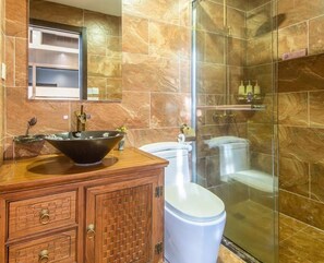 A bathroom with a wooden vanity, a large bowl sink, a toilet, and a glass shower enclosure. - Floral Hotel Aranya Resort Hangzhou (Hangzhou)