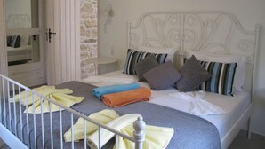 A bedroom with a bed, pillows, and towels. - Villa Efthalia (Faistos)
