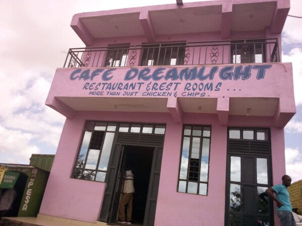 A pink building with a sign that reads "Cafe Dreamlight Restaurant & Rest Rooms."