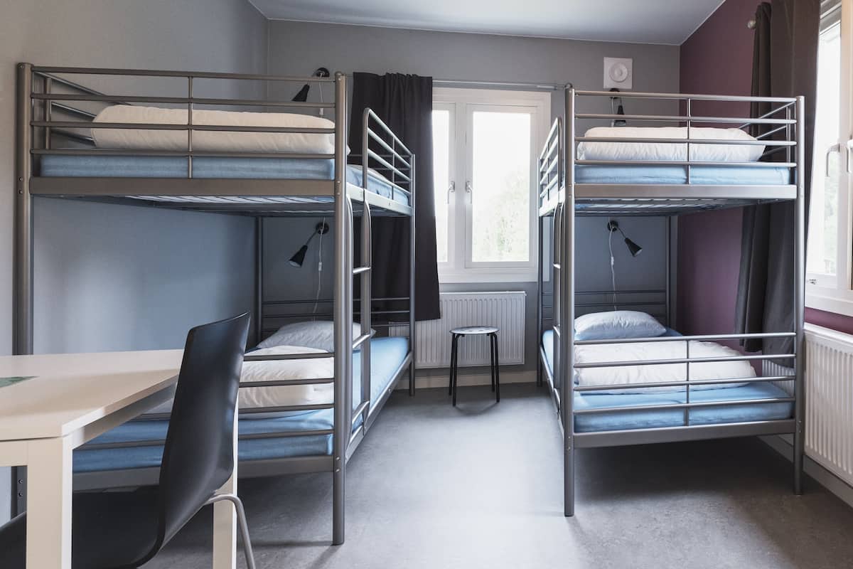 Une chambre avec des lits superposés, un bureau et une chaise.