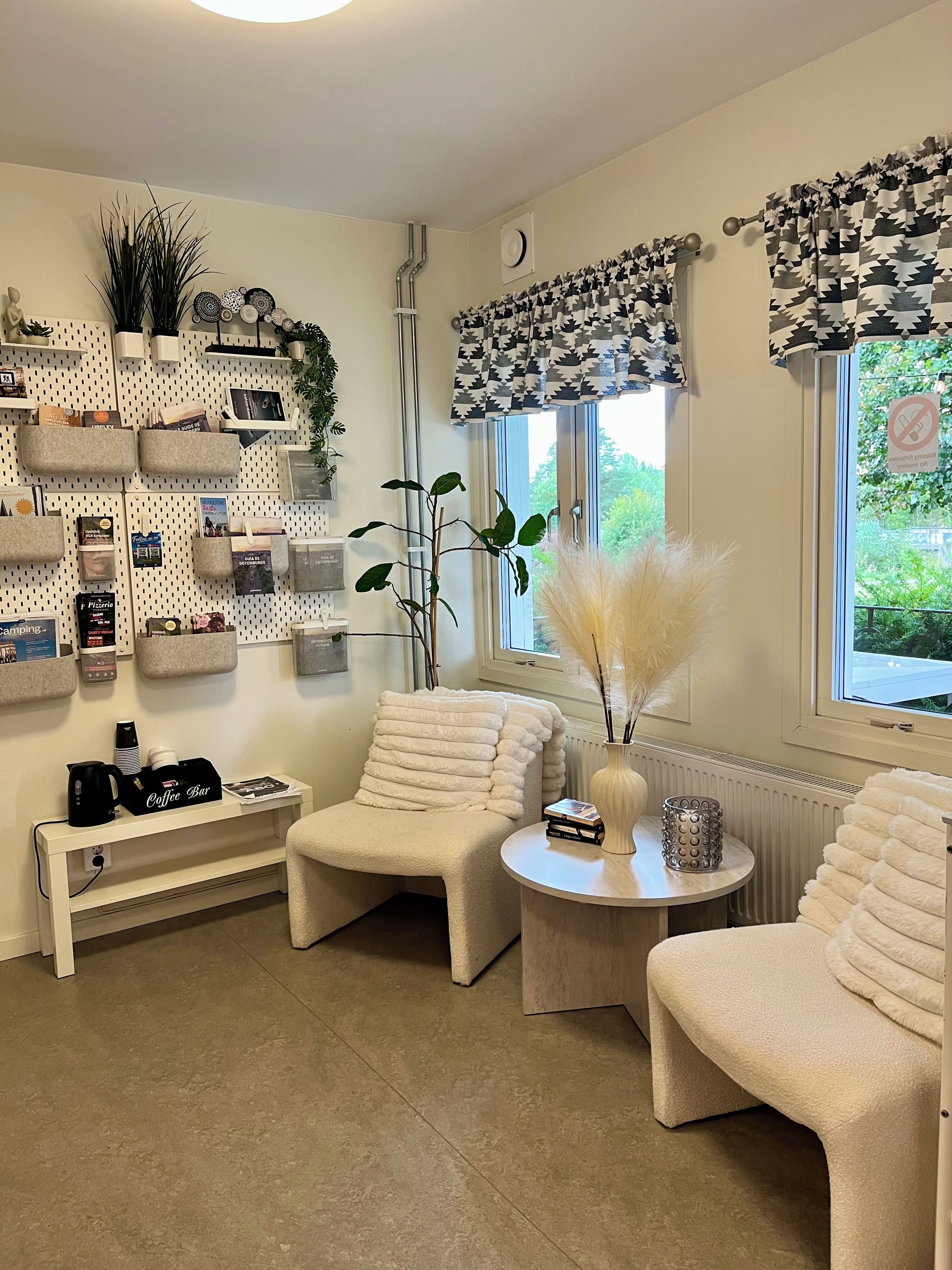 Una sala de estar moderna con un sofá, sillones, una barra para café y un estante de pared con varios objetos.
