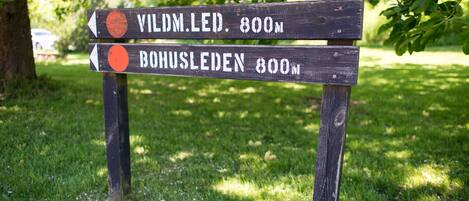 Un letrero de madera con flechas que indican 'VILDM.LED. 800m' y 'BONUSLEDEN 800m'.