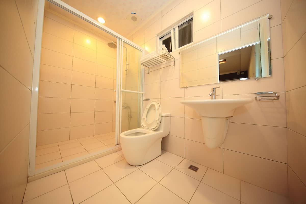 Une salle de bain moderne équipée de toilettes, d’un lavabo et d’une douche.