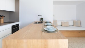 Una cocina moderna con una isla de madera, pileta de acero inoxidable y muebles de cocina blancos.