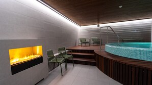 Ein moderner Poolbereich im Innenbereich mit warmer Fußbodenheizung, einem kleinen Pool und Sitzgelegenheiten.