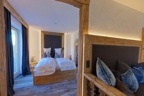Un dormitorio con una cama grande, cabecero de madera y vistas al exterior.