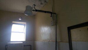 Un baño con ventana, ducha e inodoro.