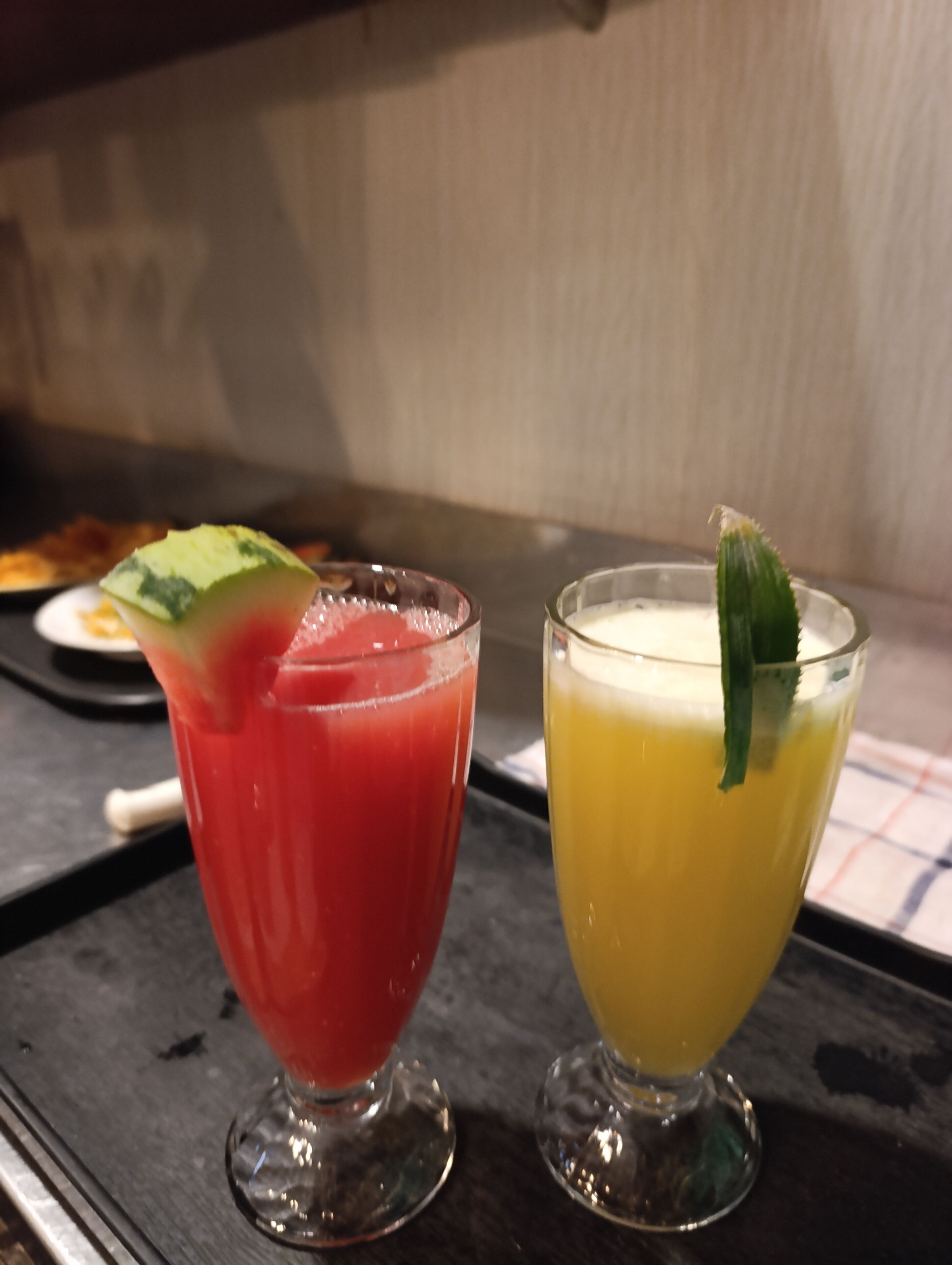 Two glasses of beverages on a table.