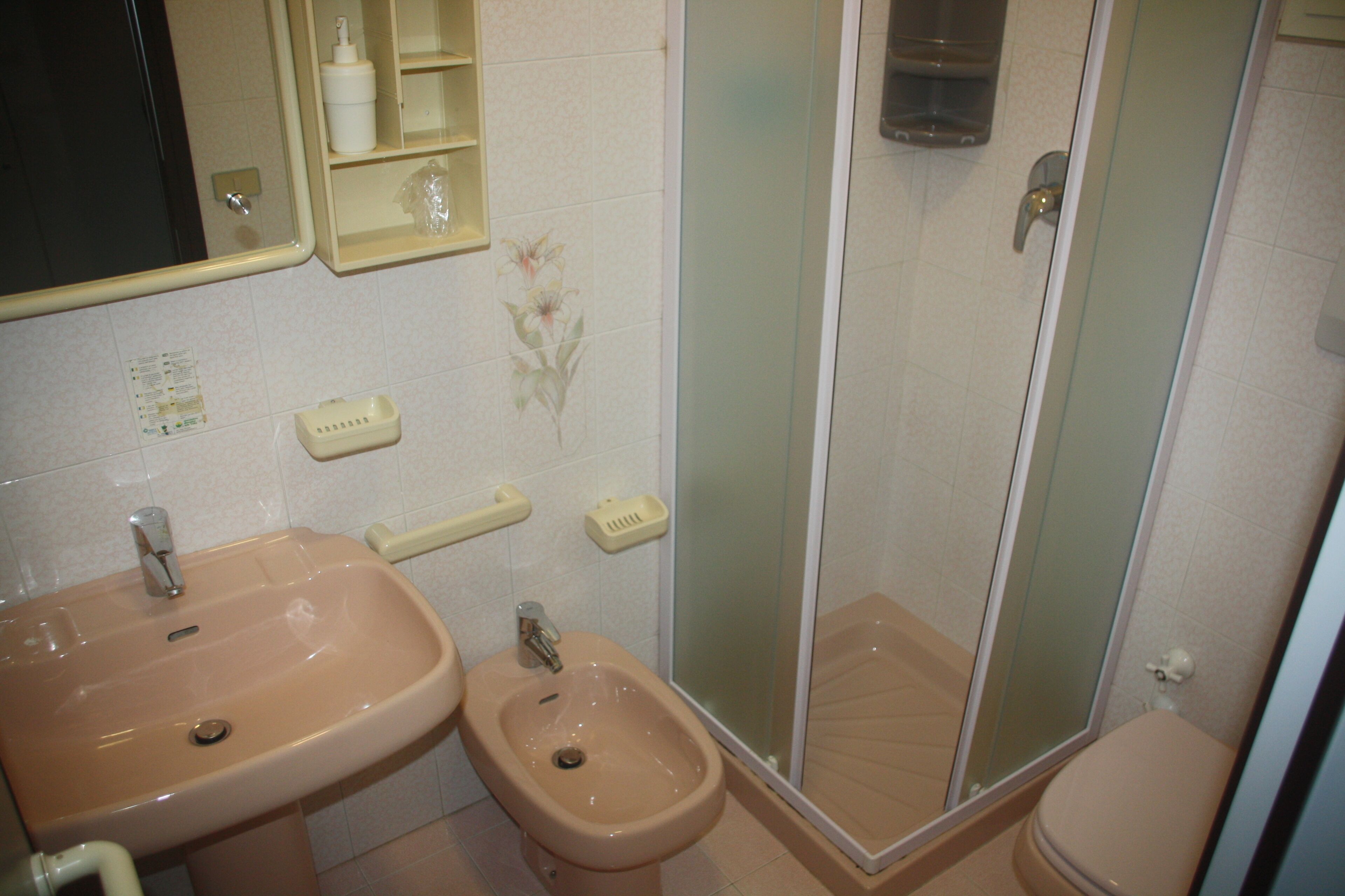 Ein Badezimmer mit zwei Waschbecken, einem Bidet, einer Toilette und einer Duschkabine.