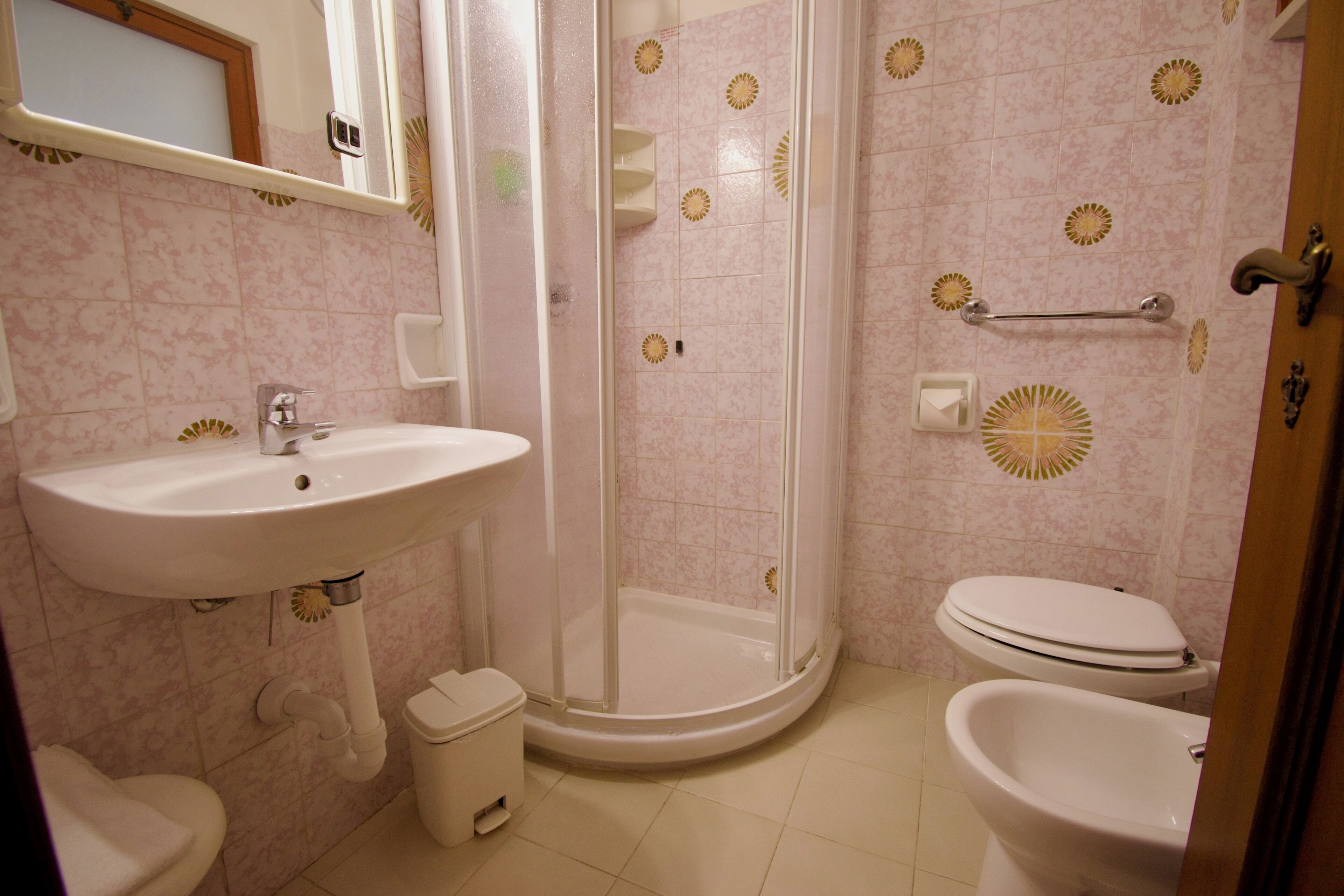Un baño con lavamanos, inodoro, ducha e inodoro con ducha.