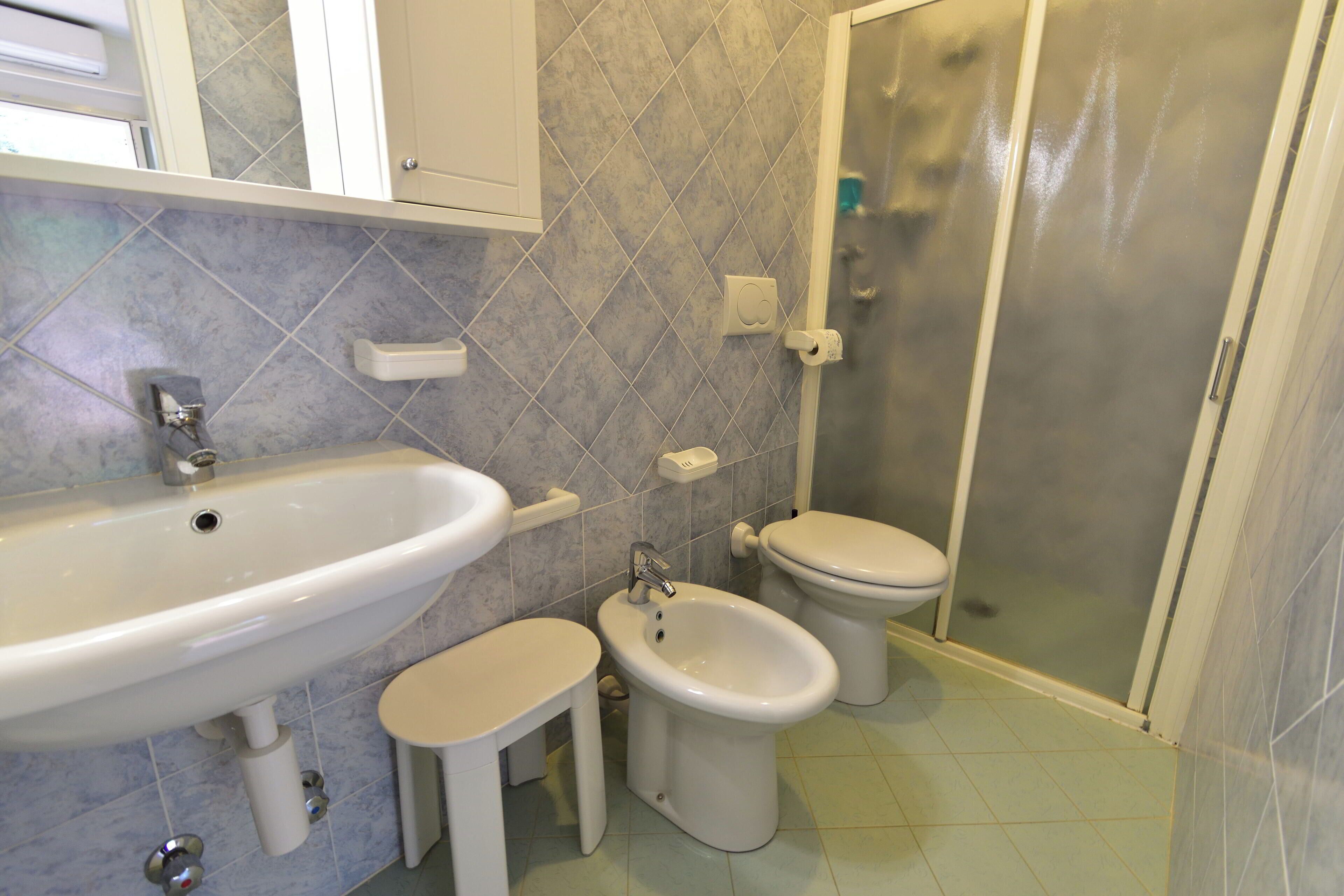 Ein Badezimmer mit Waschbecken, Bidet, Toilette und Dusche.