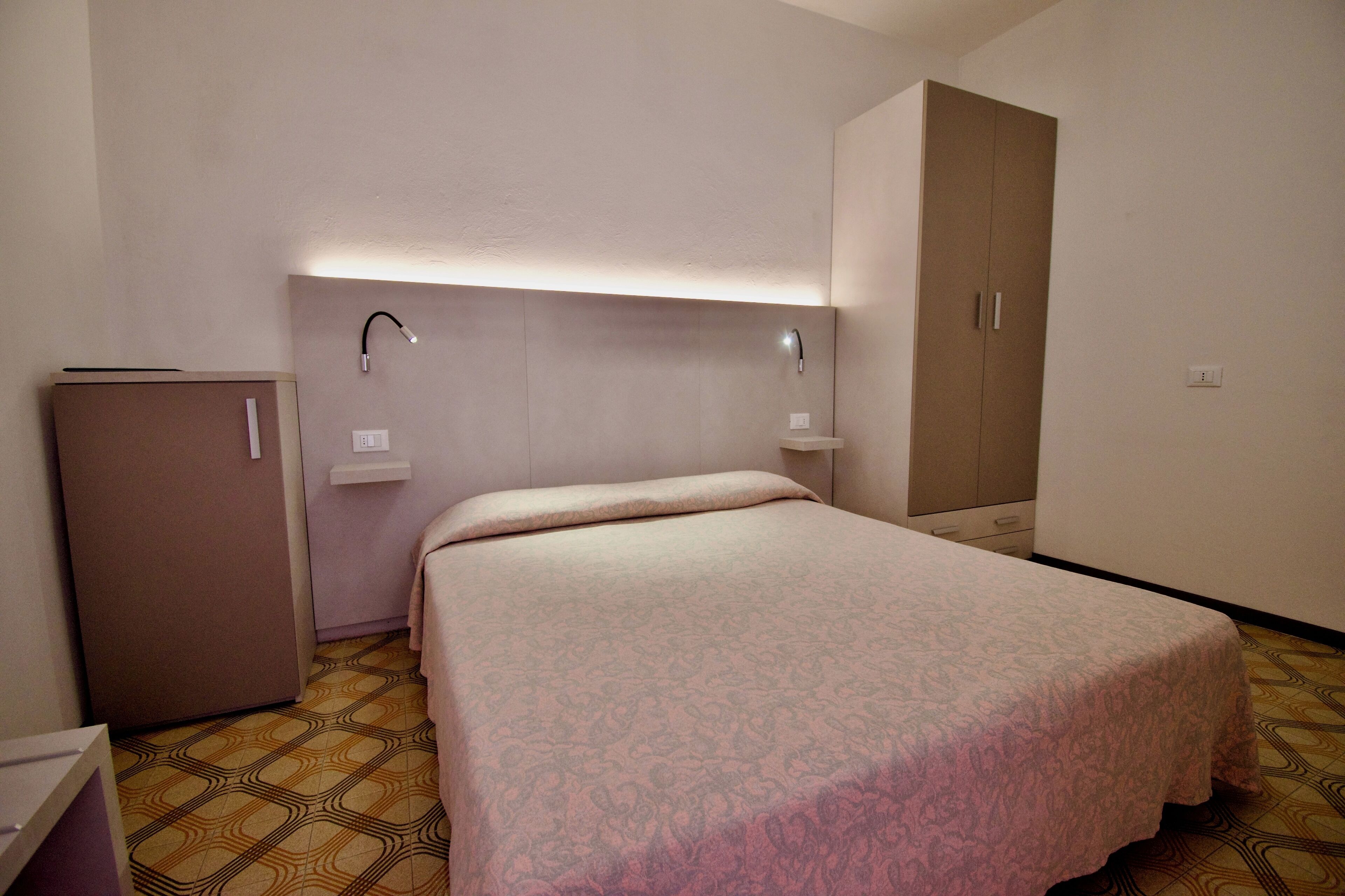 Une chambre à coucher avec un lit, une armoire, un bureau et un miroir.