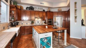 Una cocina moderna con armarios de madera, una isla central y una estantería empotrada.