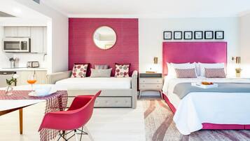 Ein modernes Schlafzimmer mit einem großen Bett, einem Nachttisch, einem roten Sessel und einem Essbereich mit Tisch und Stühlen.