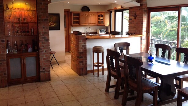 A kitchen with a brick island, wooden cabinets, and a dining area with a table and chairs.