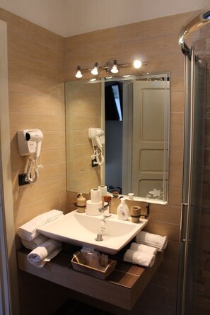 A bathroom with a sink, mirror, towel rack, and a shower area. - Agriturismo L' Impero Romano (Gerace)