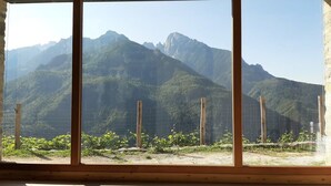 A room with large windows offering a view of a mountainous landscape.