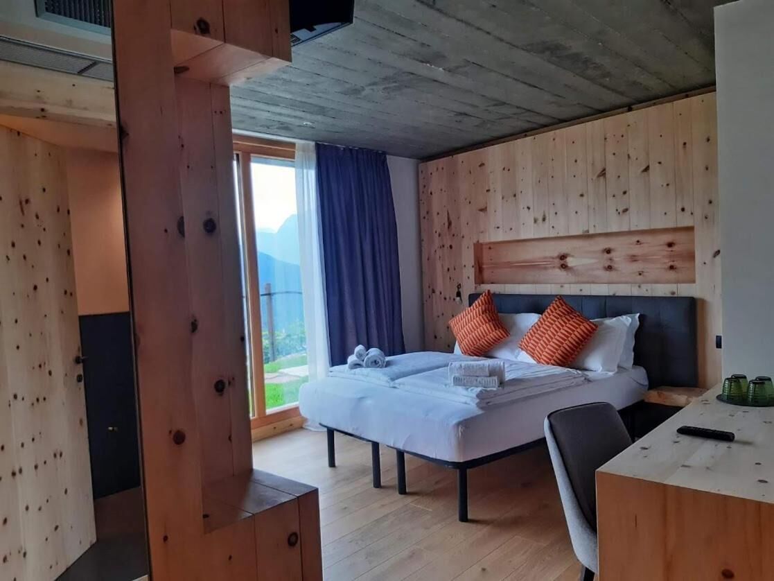 Un dormitorio con una cama, un escritorio y un ventanal amplio.