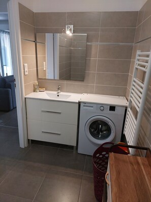 Regadera, secadora de cabello, toallas, papel de baño 