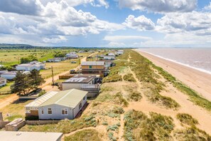 Una zona costera con casas de playa, una playa de arena y cielo despejado.